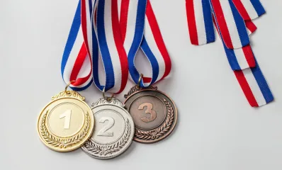 Gold, silver and bronze medals on red, white and blue ribbons